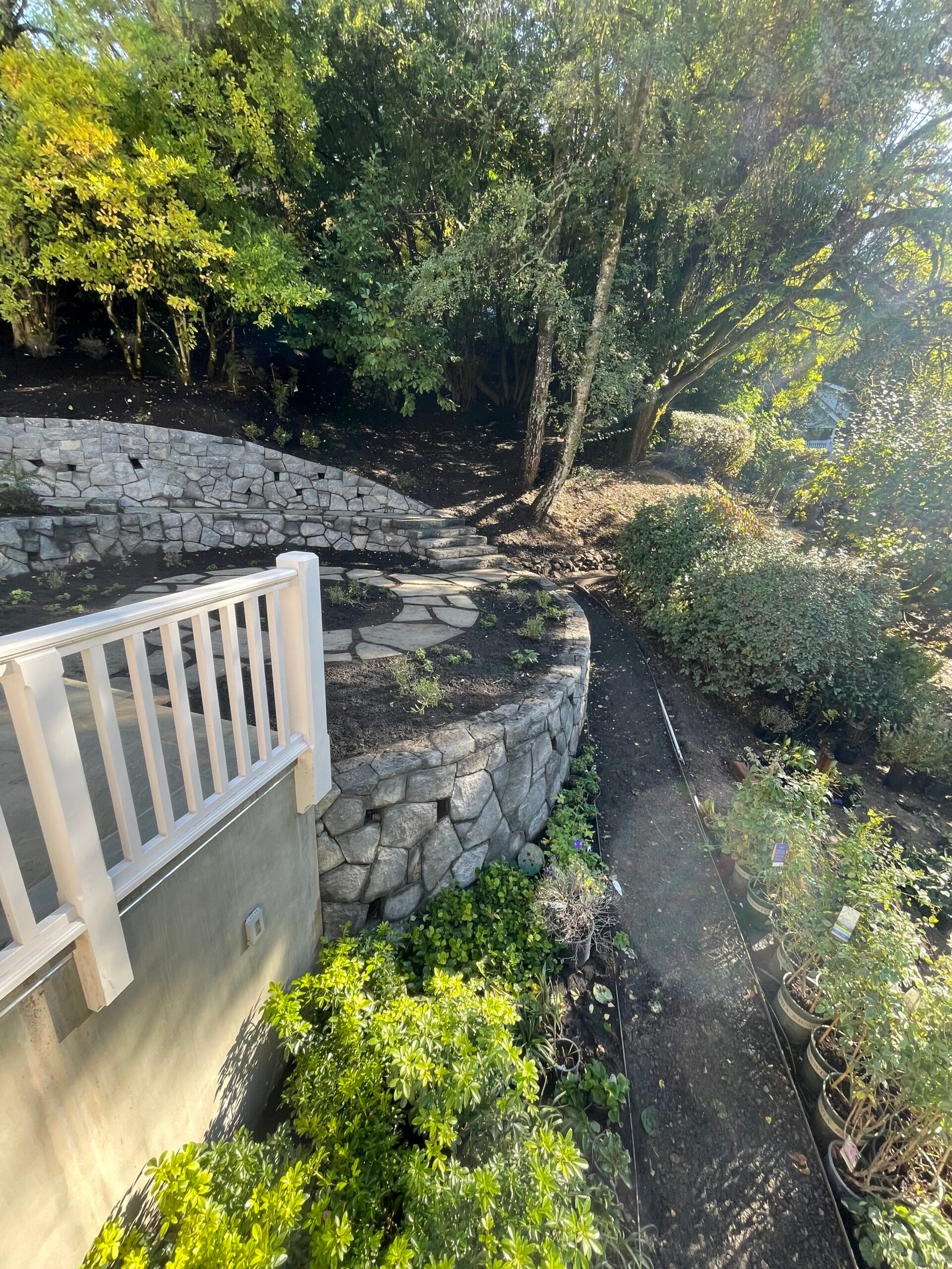 Tiered stone retaining wall with landscaped planting beds